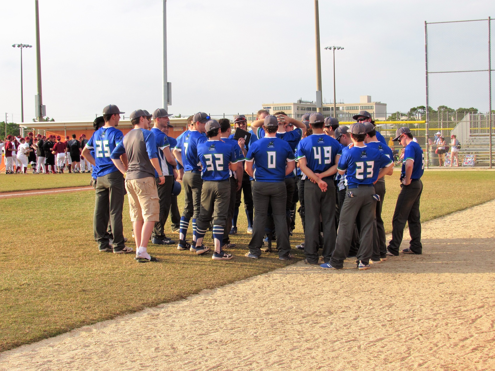 Baseball team huddling near their dugout in between innings