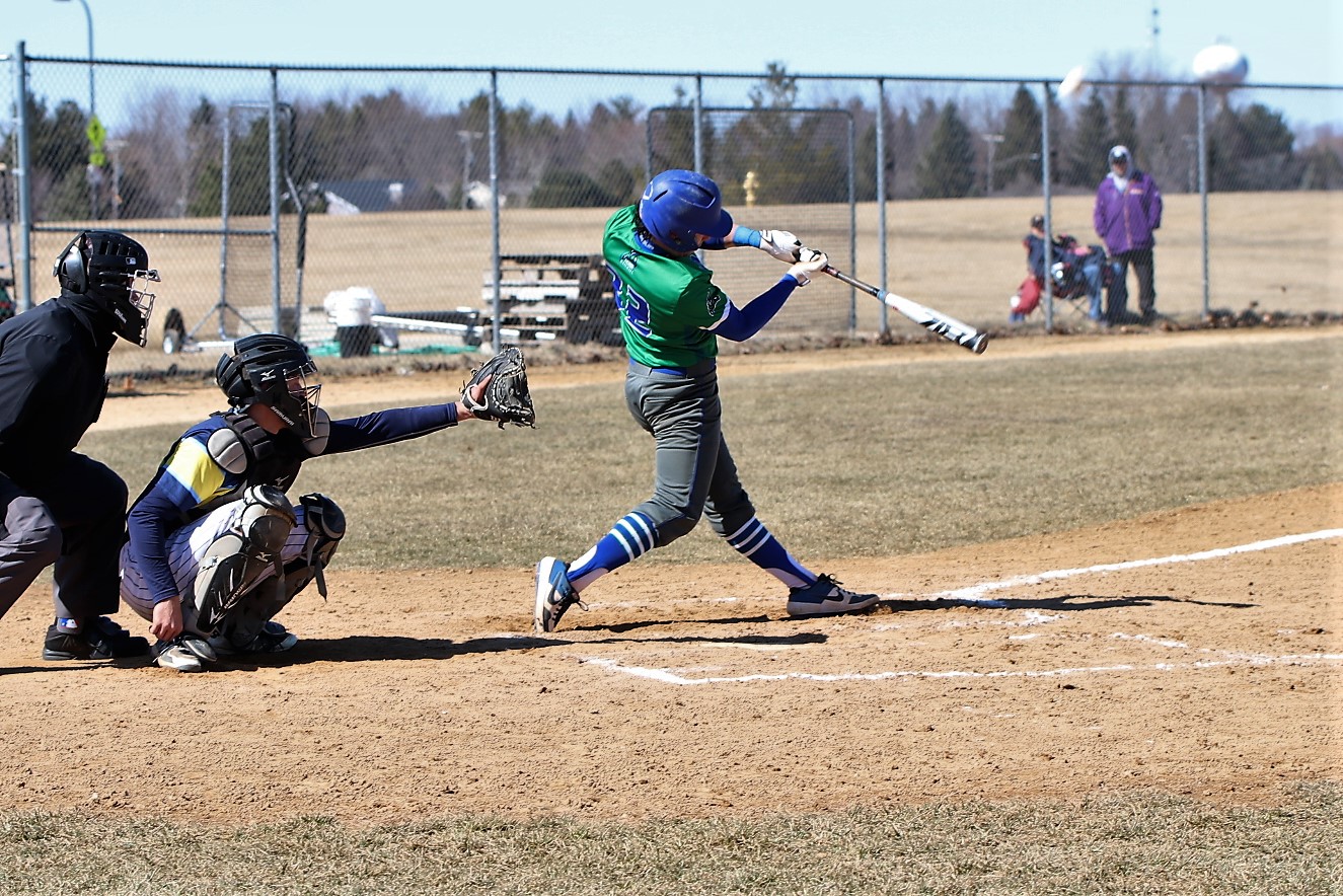Oliver Dunn mid swing, ball can be seen leaving his bat in the air