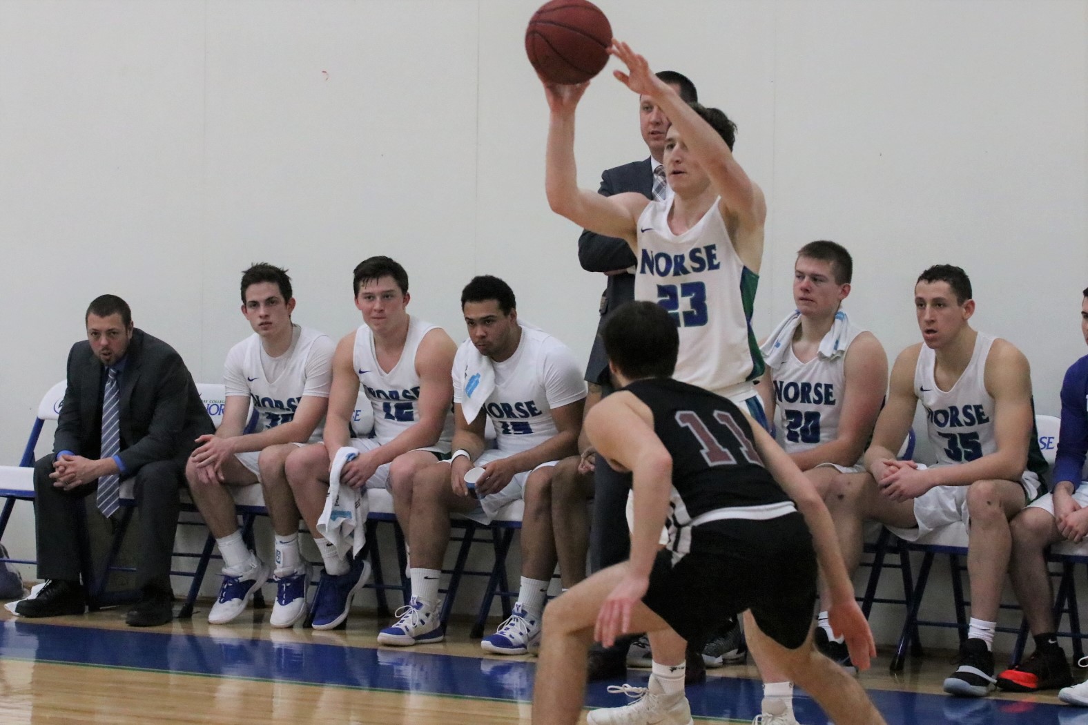 Marcus McKenney releases an overhead pass in front of the Bay bench