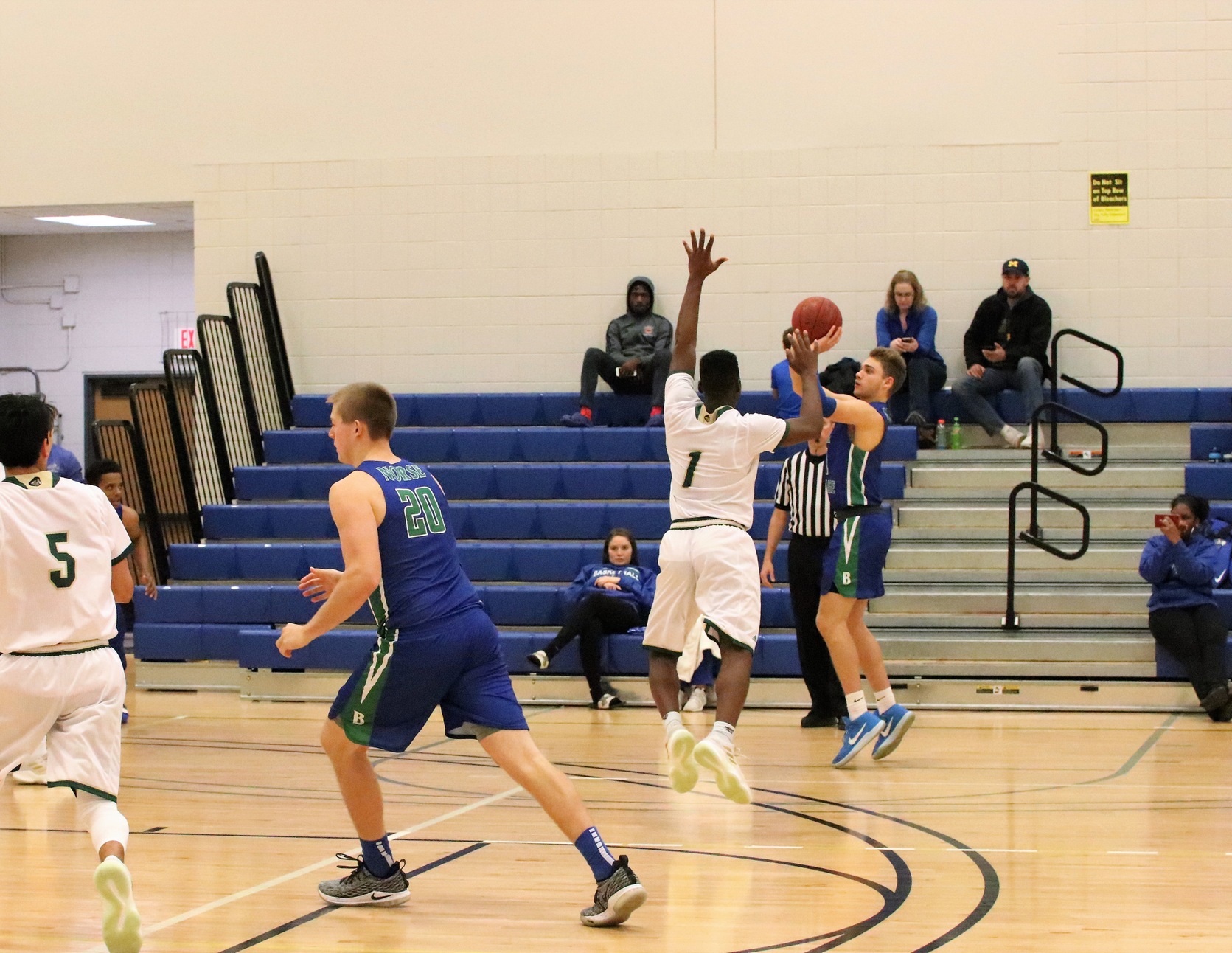 Ryan Robinette releasing a three from the right wing a defender jumping in the air from the lane to try and defend