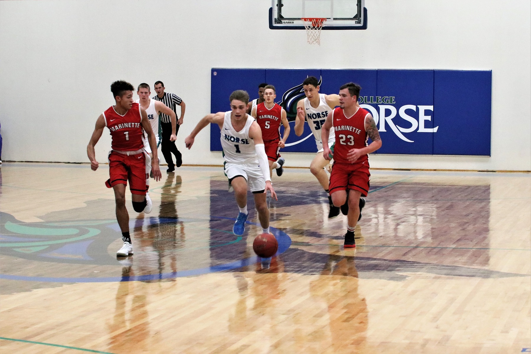Ryan Robinette leading a fast break at mid court, a pack of players behind him