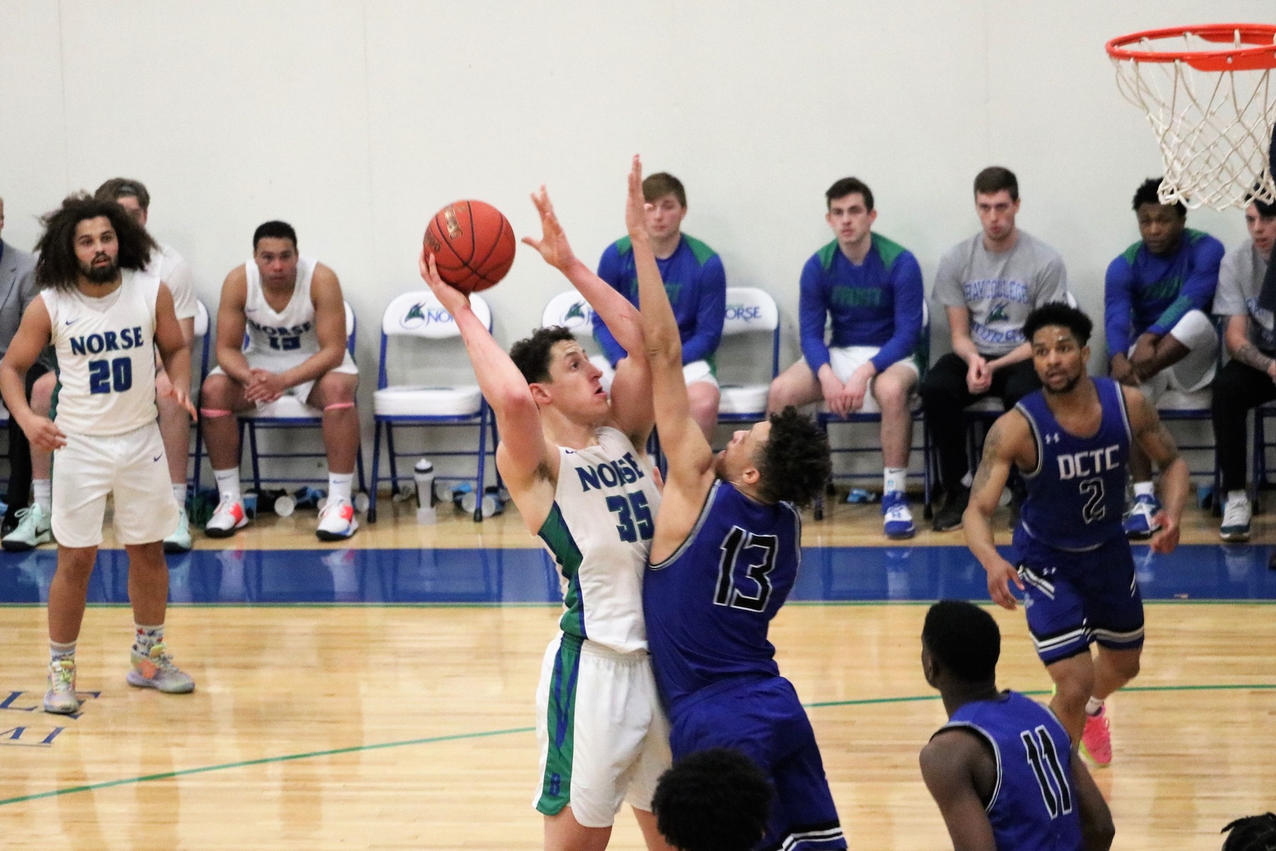 Christian Alexander jumping to shoot in the lane with a defender closely guarding