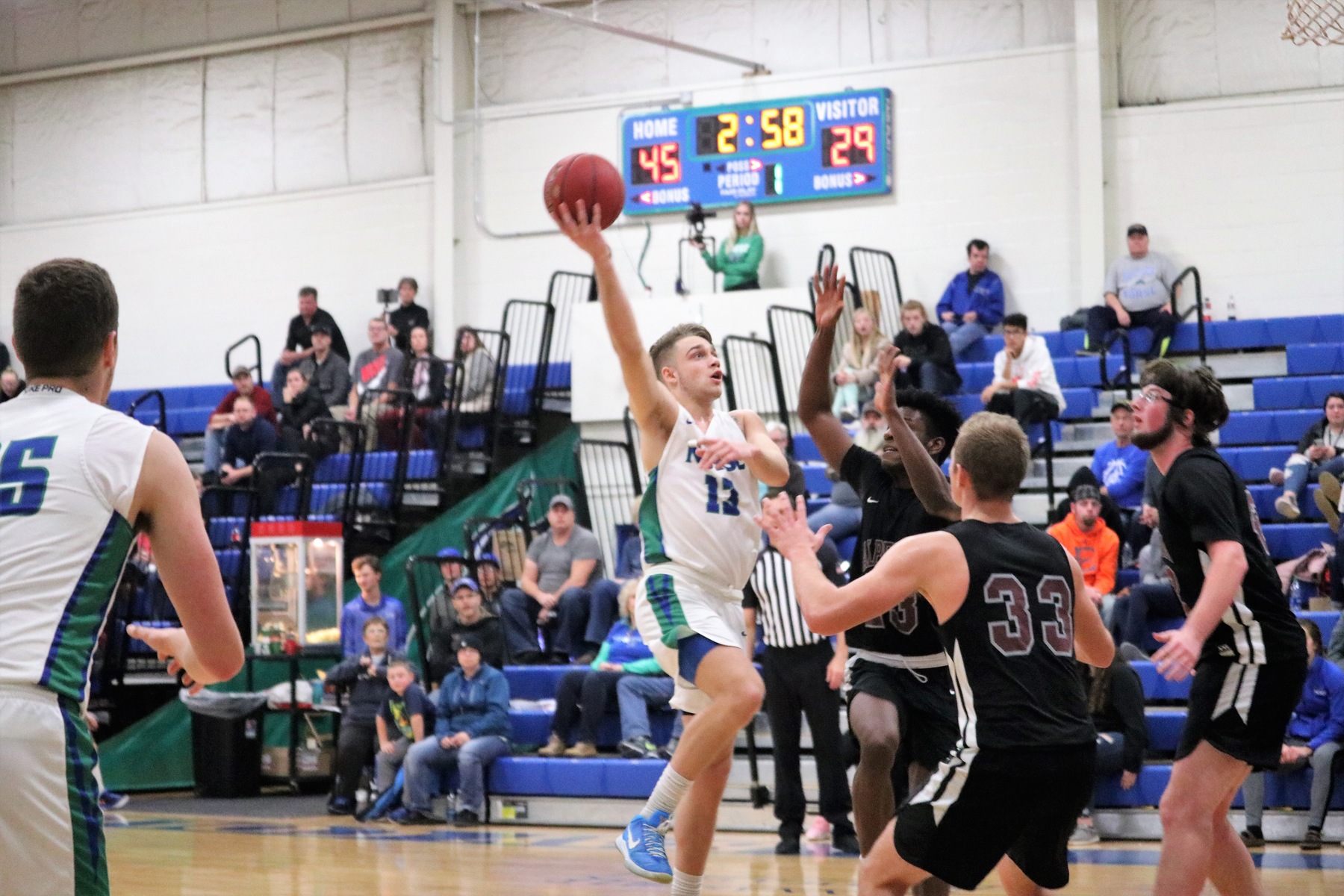 Ryan Robinette shoots a hook shot in front of two defenders