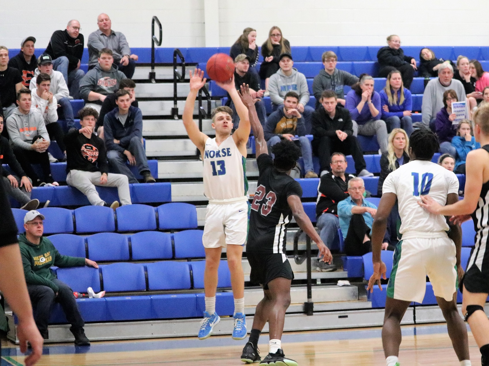 Ryan Robinette shooting a three from the corner in front of a defender