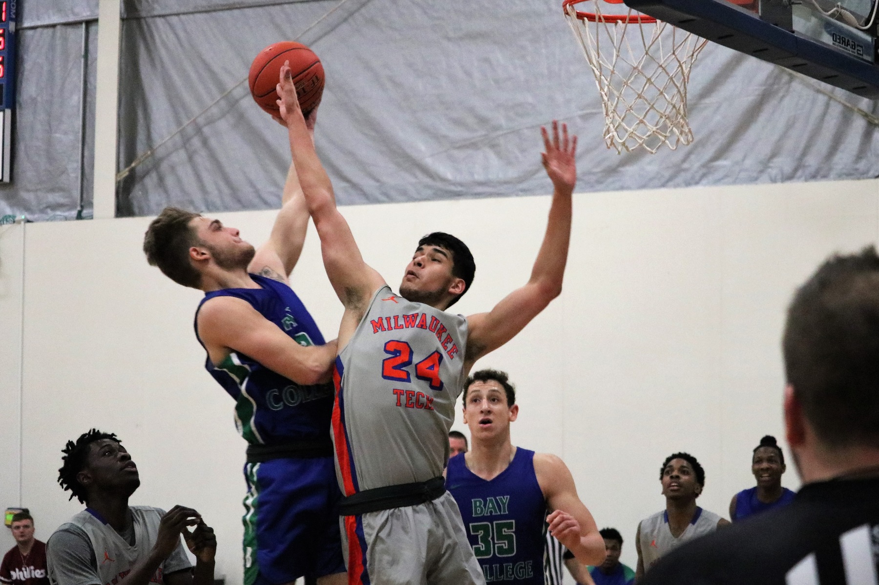 Ryan Robinette shooting near the rim as a defender jumps in front of him