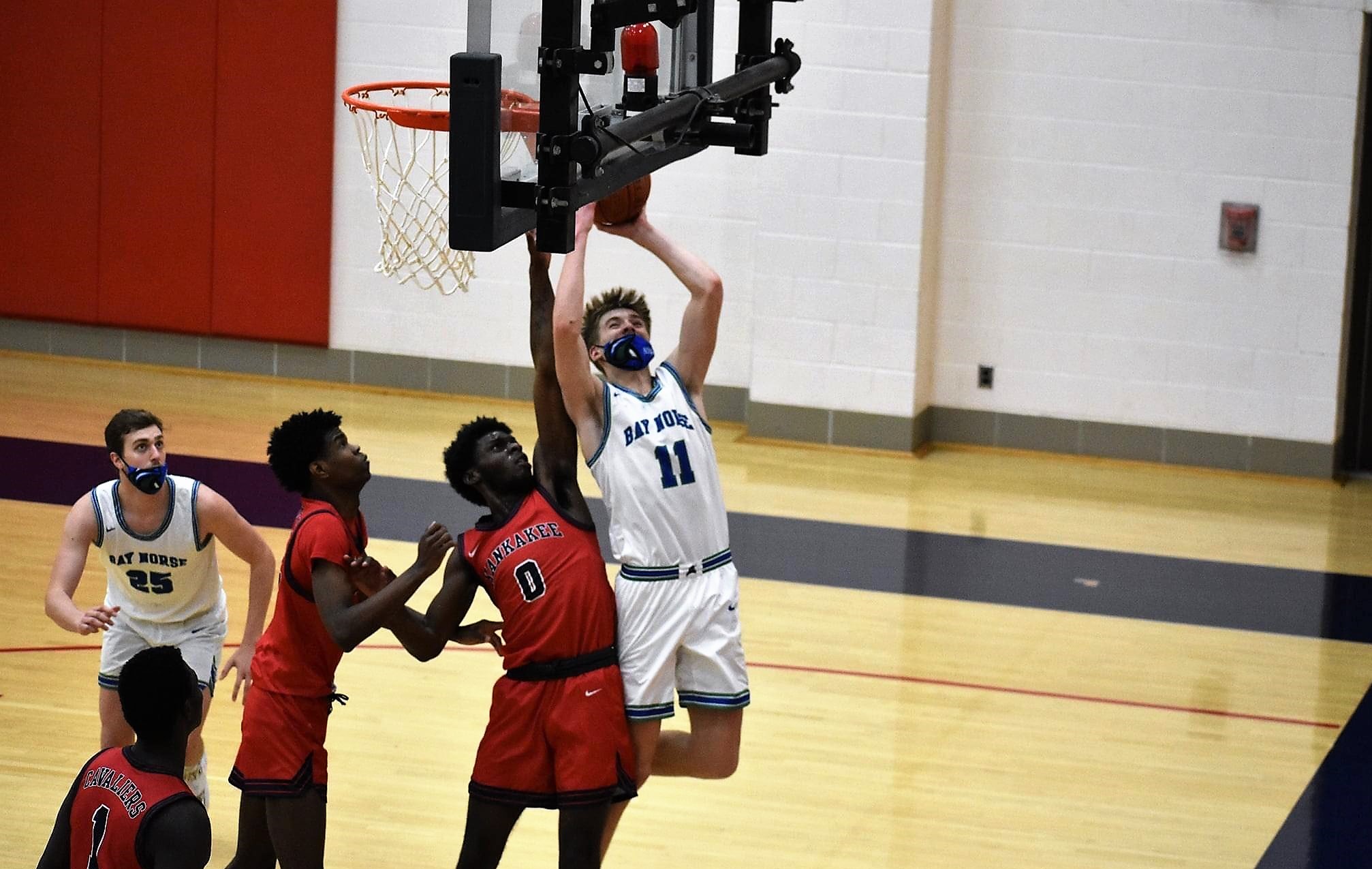 Ashton Janke putting up a shot on the right side of the rim, a defender is trying to block his attempt