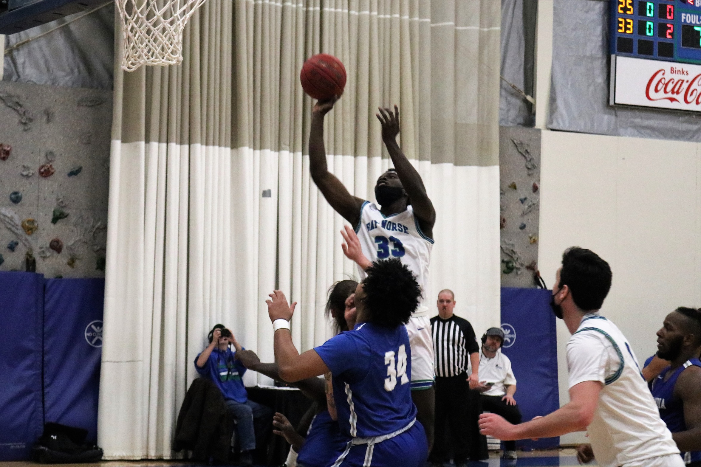 Didier Ngambo lifts above the defenders to shoot a shot in the lane