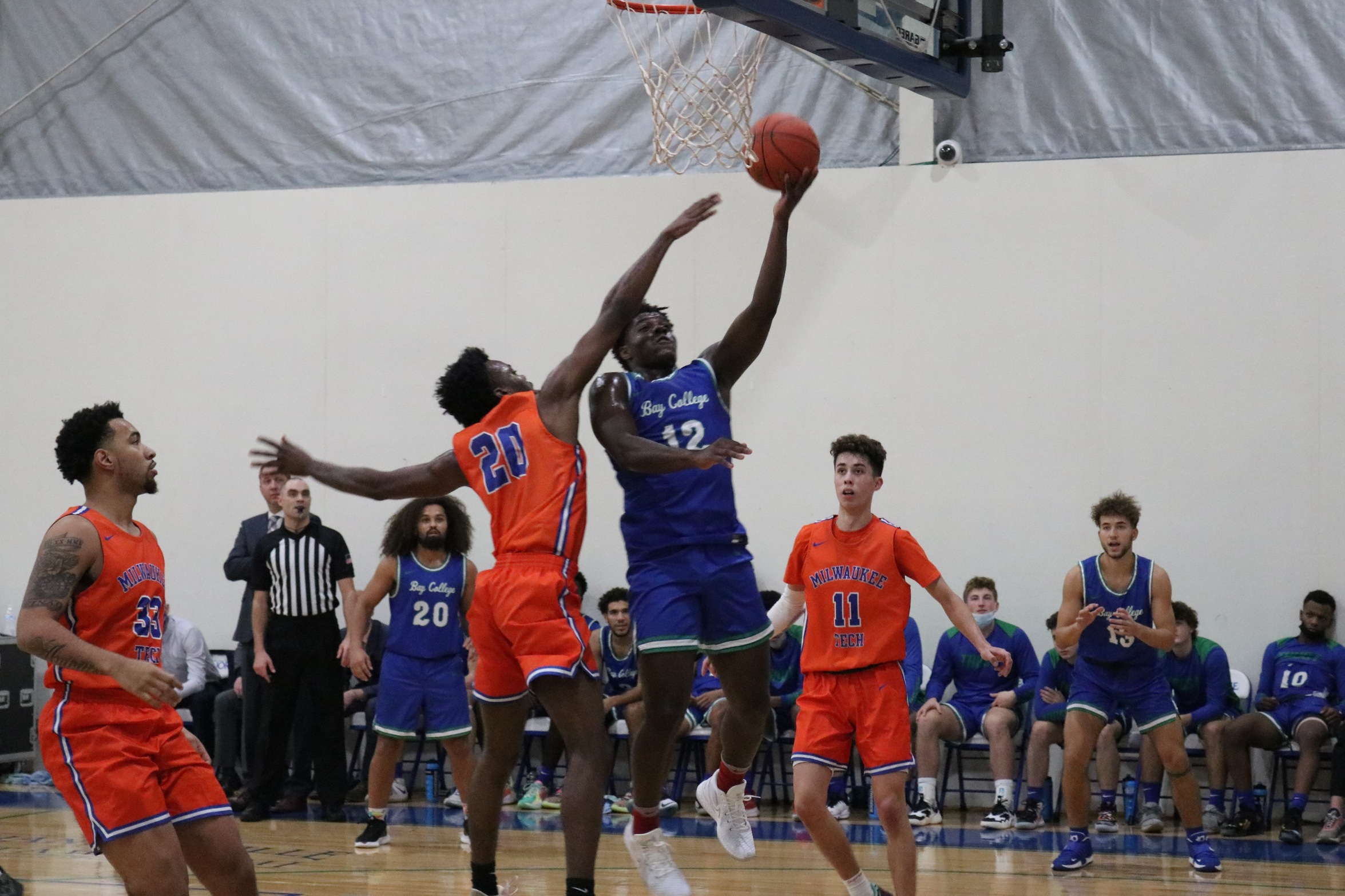 Isaiah Kennedy going in for a layup as a defender tries to block his attempt