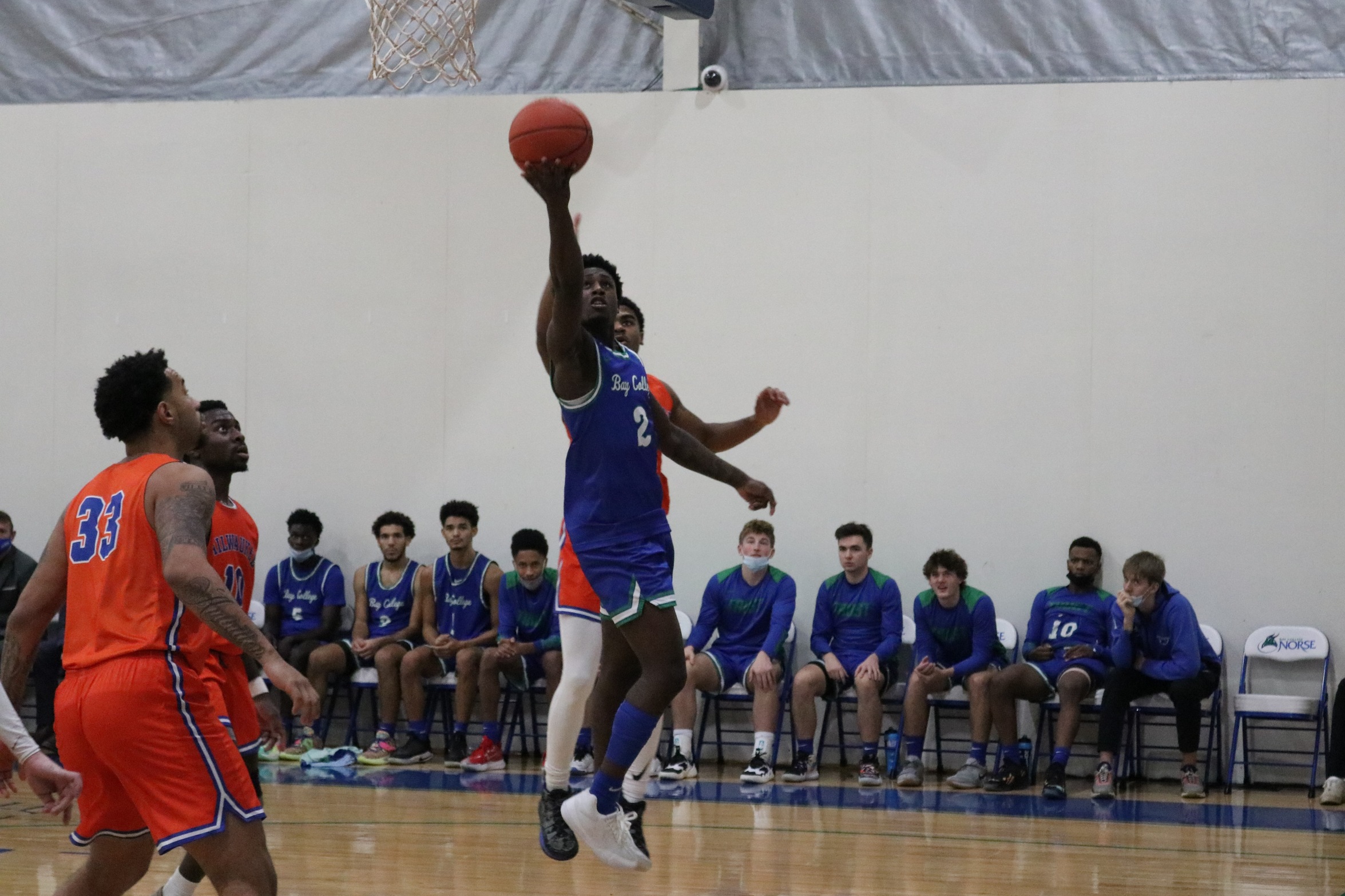 Dewayne Thompson lifting a shot with defenders looking on