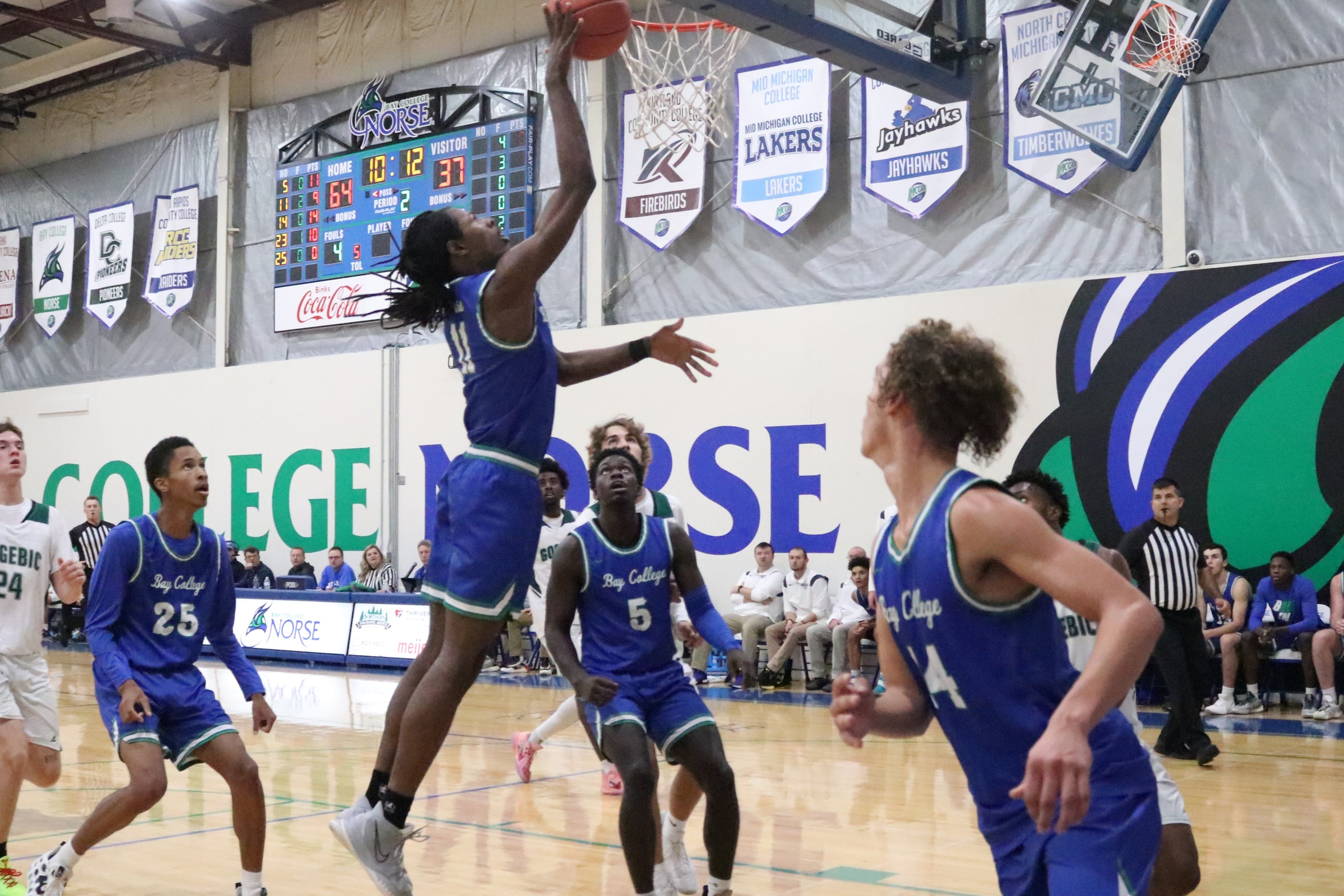 Genesis Kemp going up for a layup as teammates look on