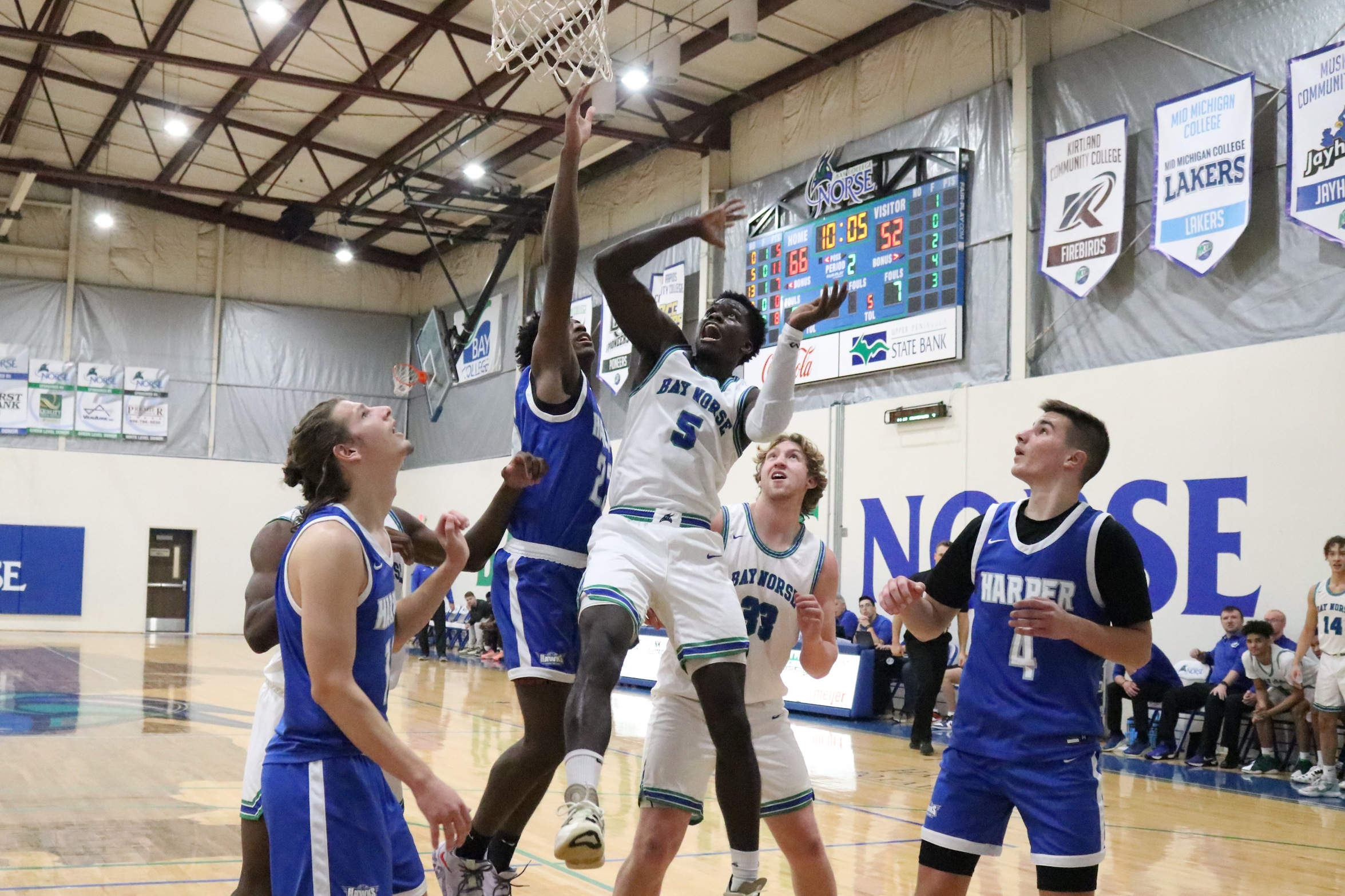Jaylen Flaniken in mid air, as he Carter Hudson, and Harper defenders watch his shot in the air