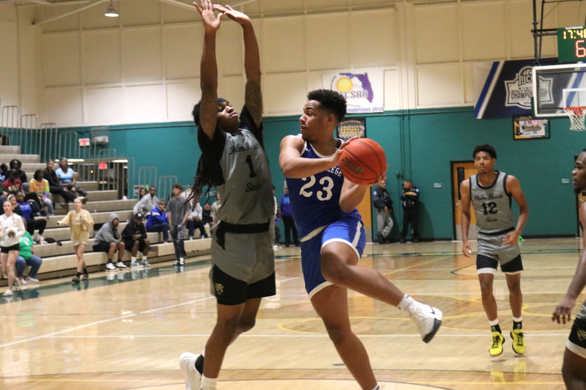 Josh Williams looks to pass to the opposite corner after a drive down the lane line.  A defender has his arms up.