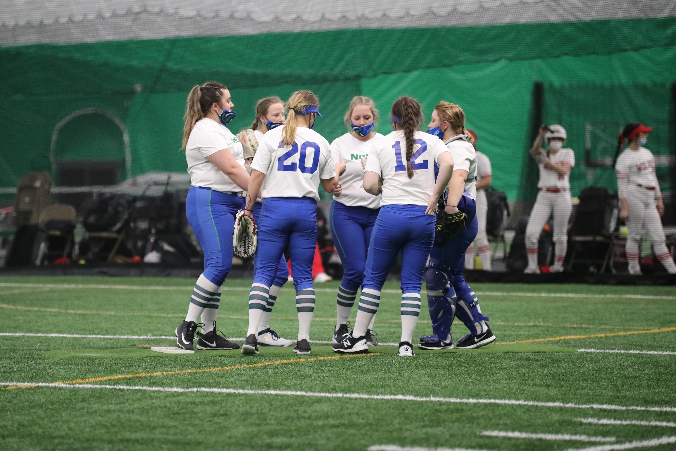 The Norse infielders gather around the pitcher's mound
