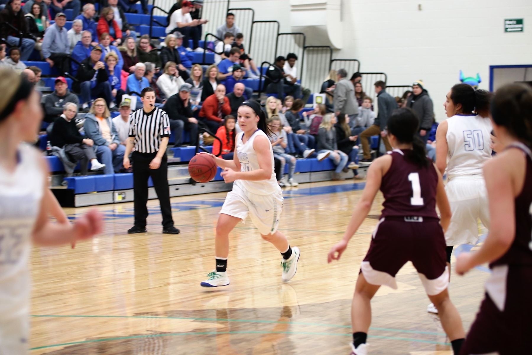 Taylor Hunter dribbles to her right, several players look on