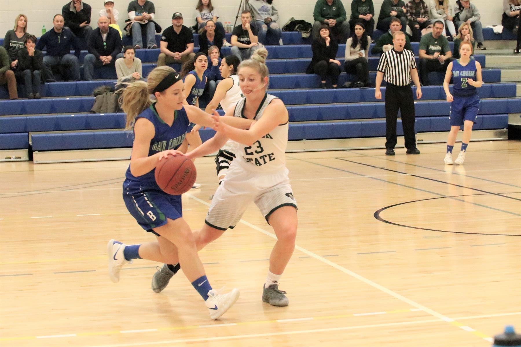 Haley Trudell dribbling to her right, a defender is close by, Haley is trying to hold her off as the defender reaches in