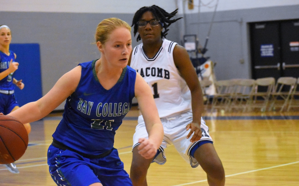 Alaina Trudeau dribbles the ball with a defender looking on.