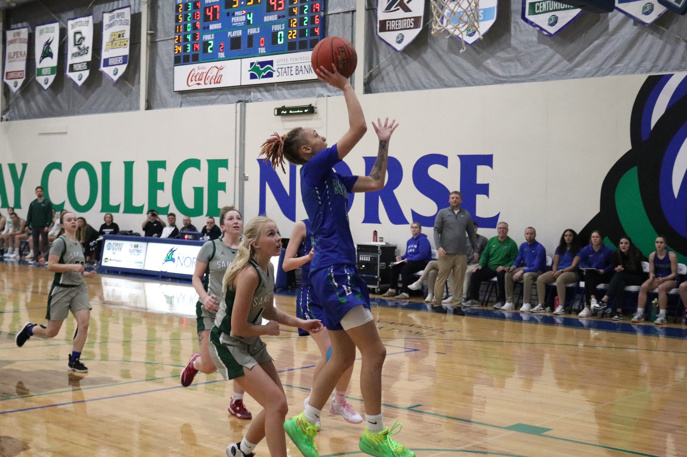 Ashlee Burchette about to release a fast break layup as defenders trail the play