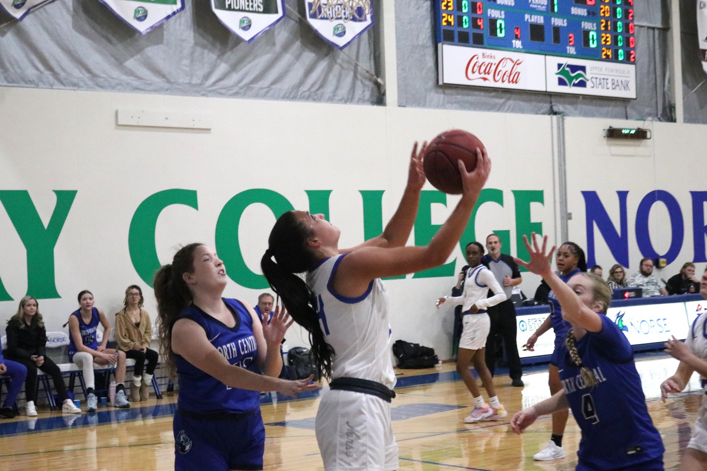 Laruen Zawada goes up for a reverse layup with two defenders looking on
