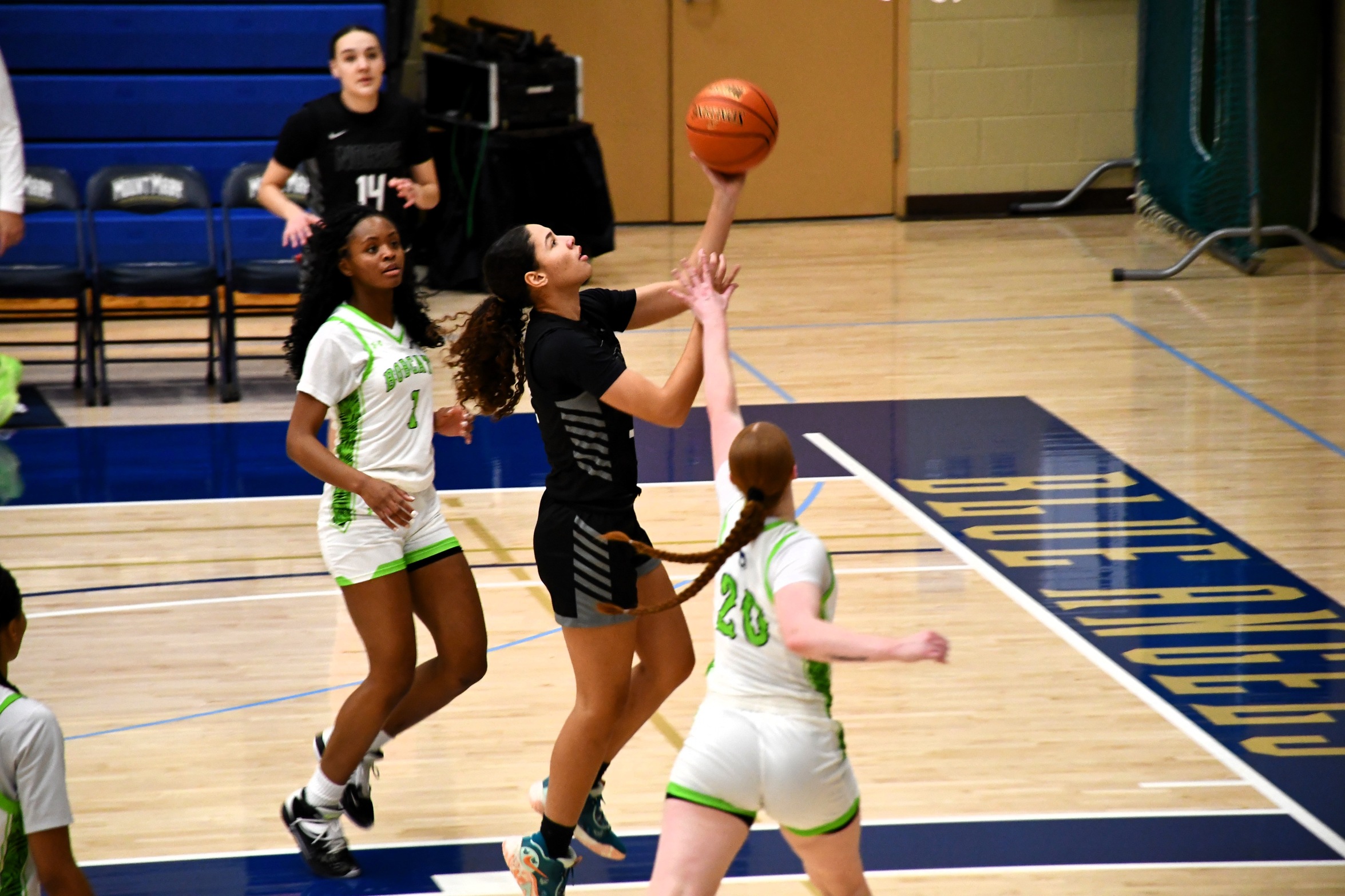Kyra Anders goes up for a shot in the lane, two defenders are nearby