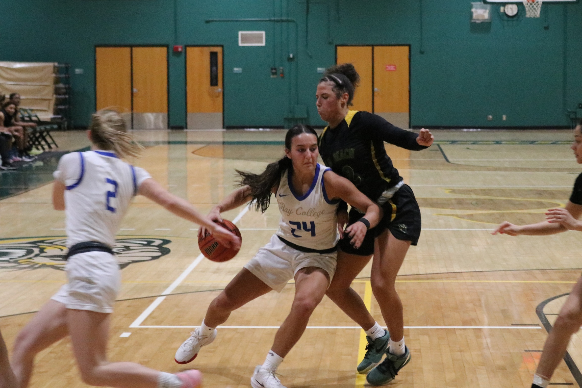 Lauren Zawada dribbles to the basket as she holds off a defender on her back