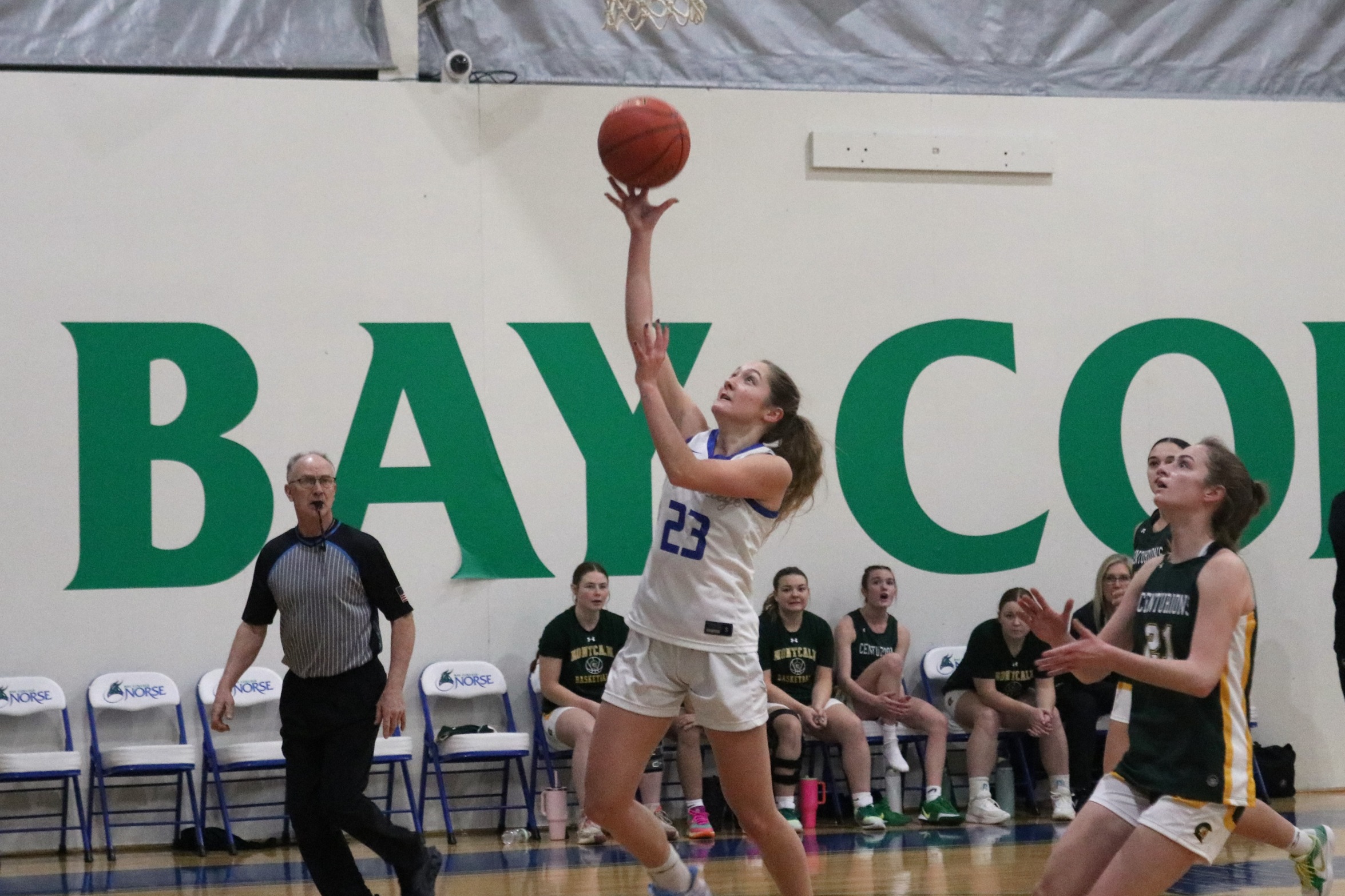 Mckenzie Hoffmeyer shots a layup as a trailing defender looks on