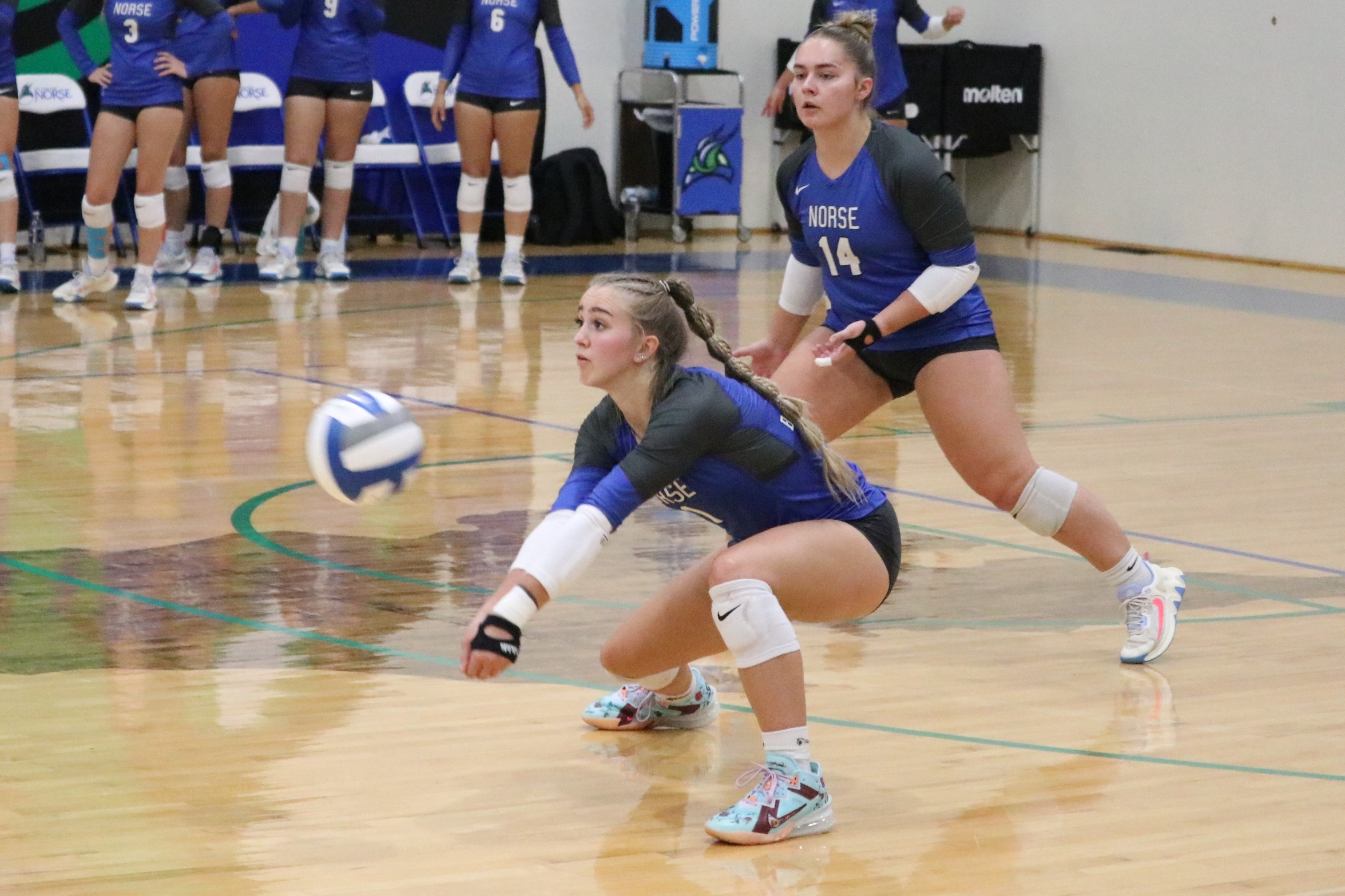 Leah Allan digs a ball as Abigail Rexford looks on