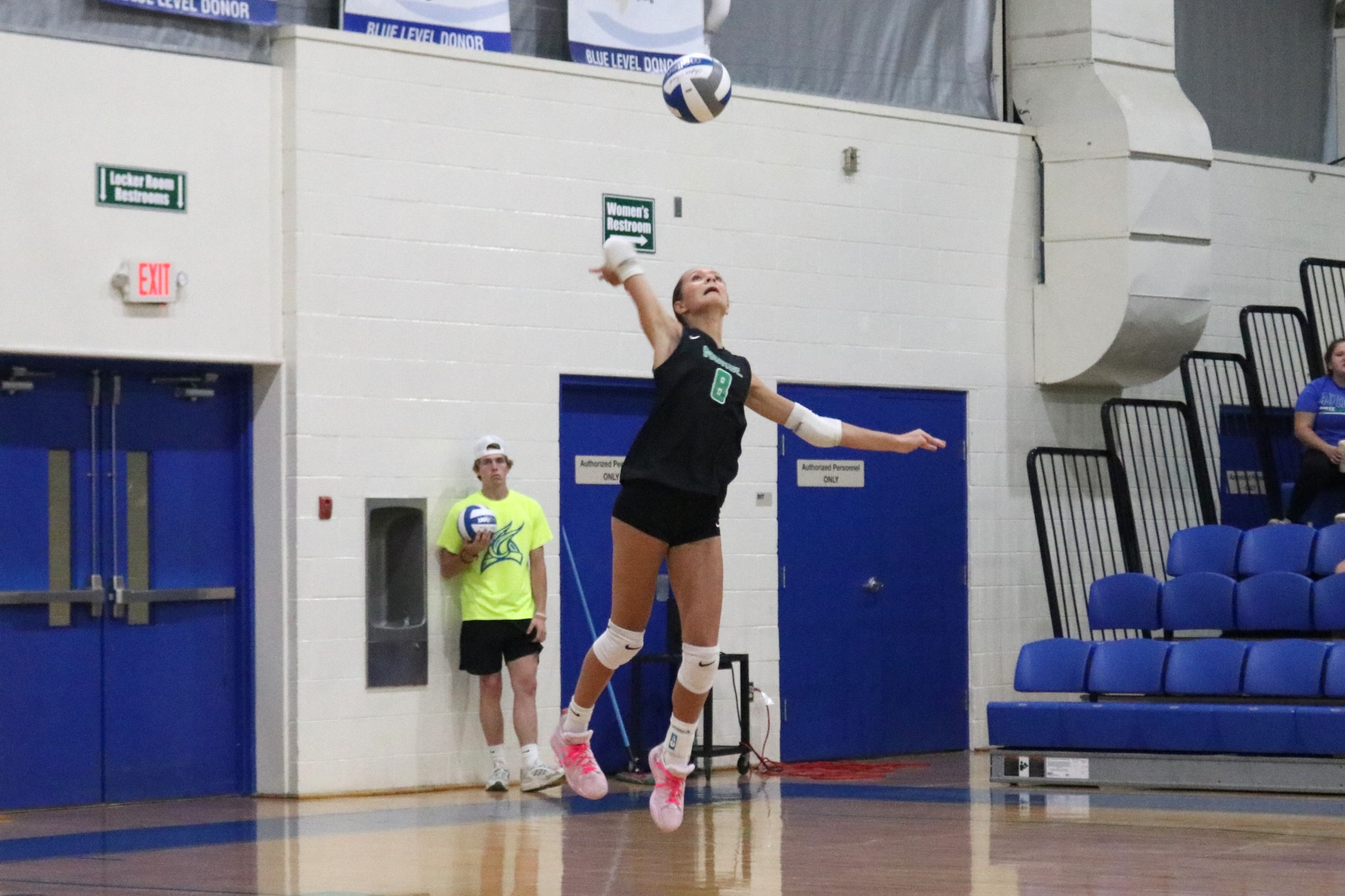 Ava Maki in mid air as she is about to hit for a serve attempt