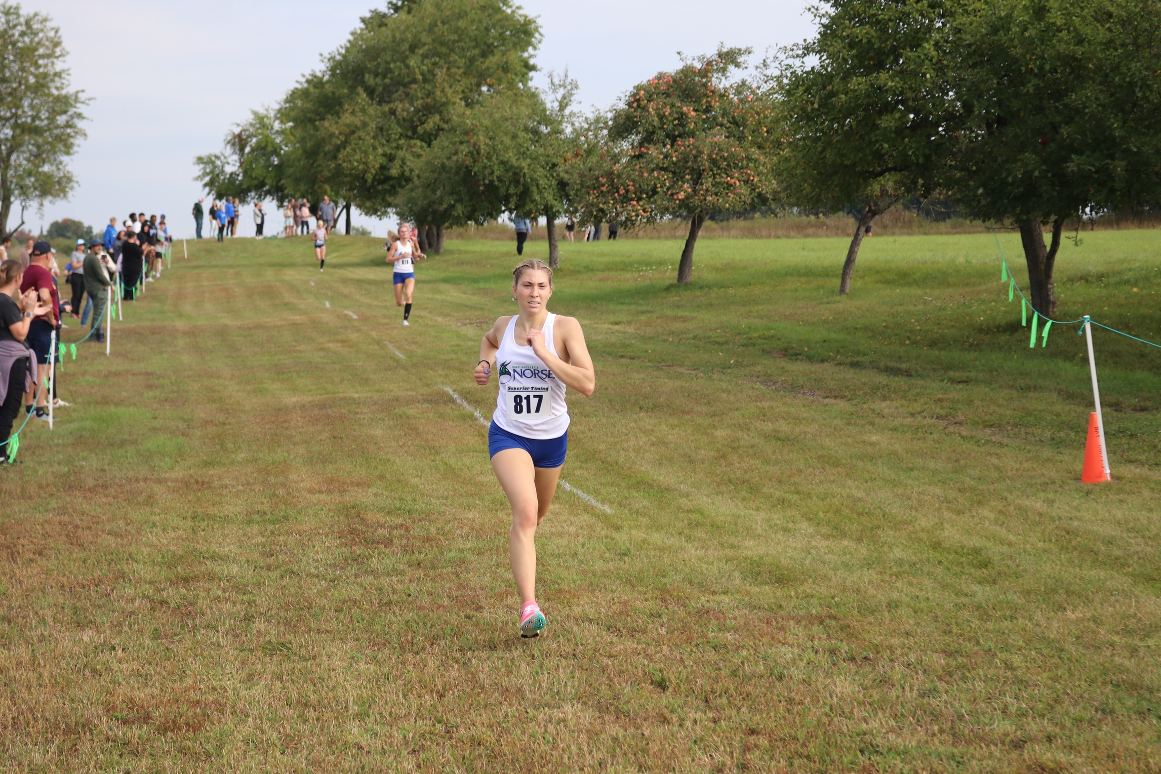 Lily Ross strides out in the final few steps of the race, Alyssa Shirkey can be seen behind her closing in on the finish